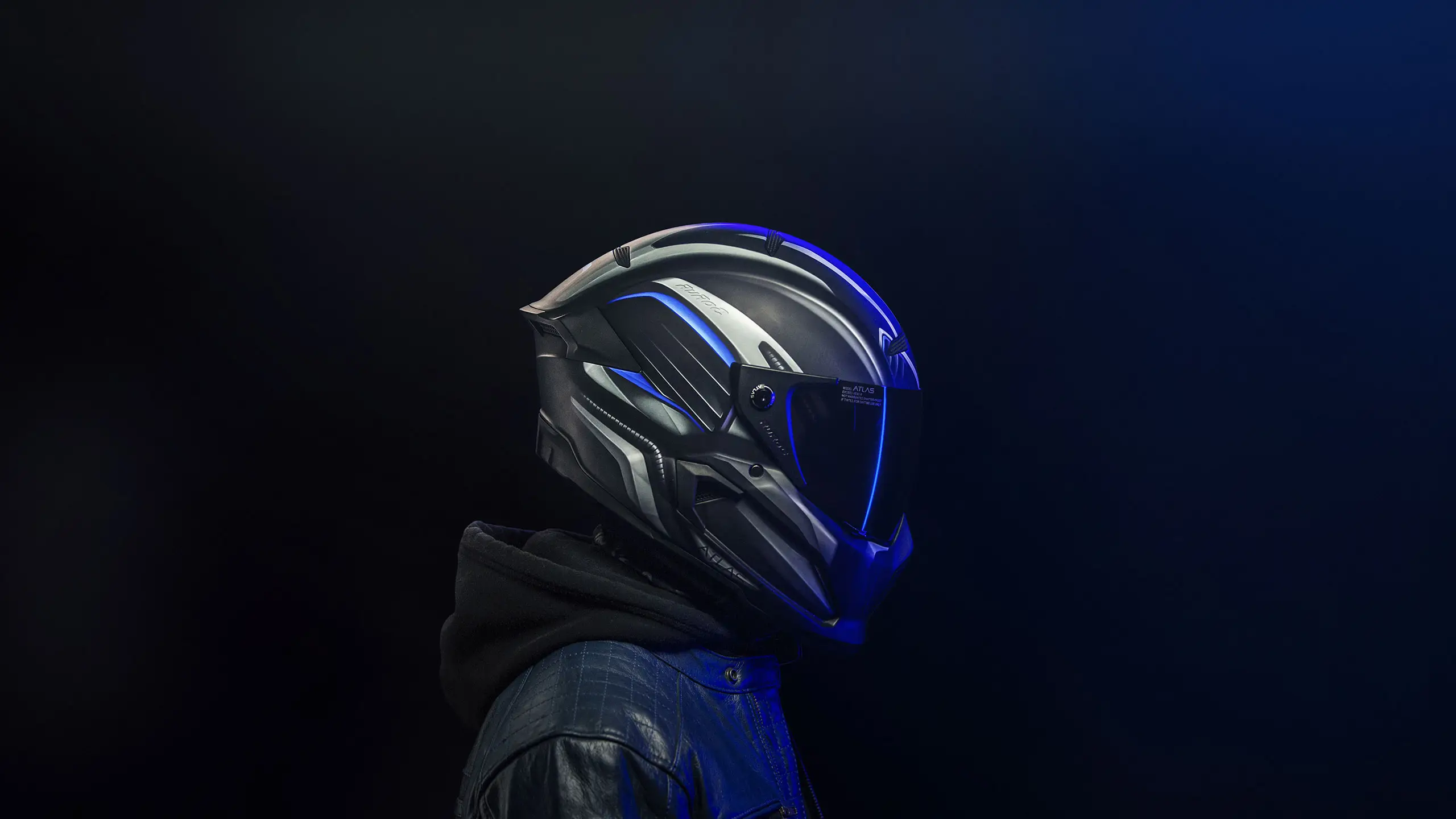 Man in motorcycle helmet in black leather jacket with black background