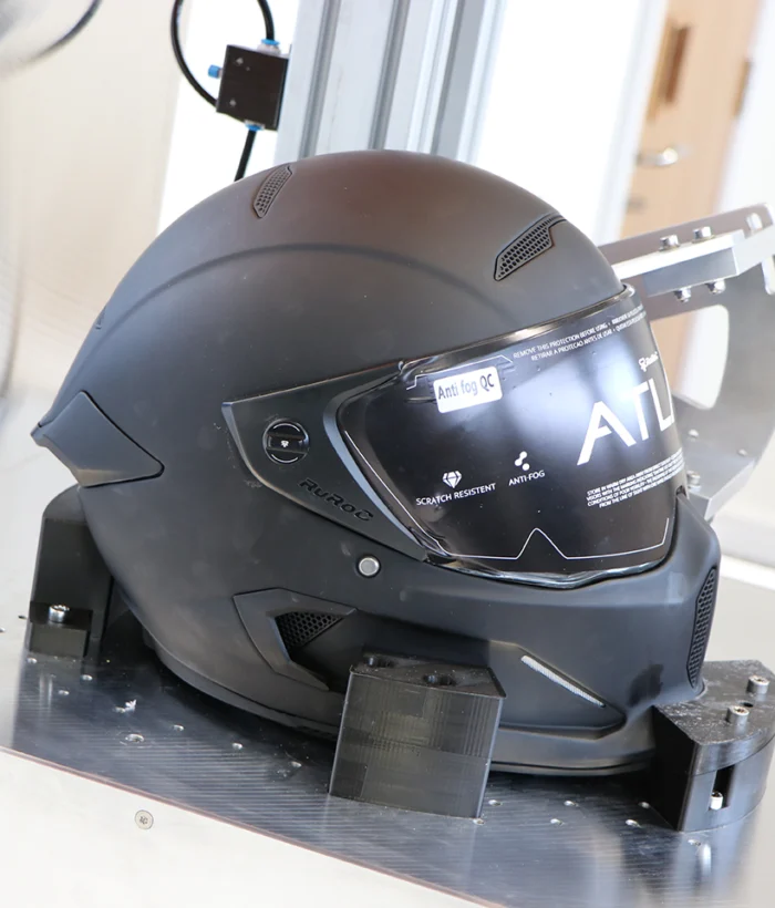 Motorcycle helmet in visor testing rig