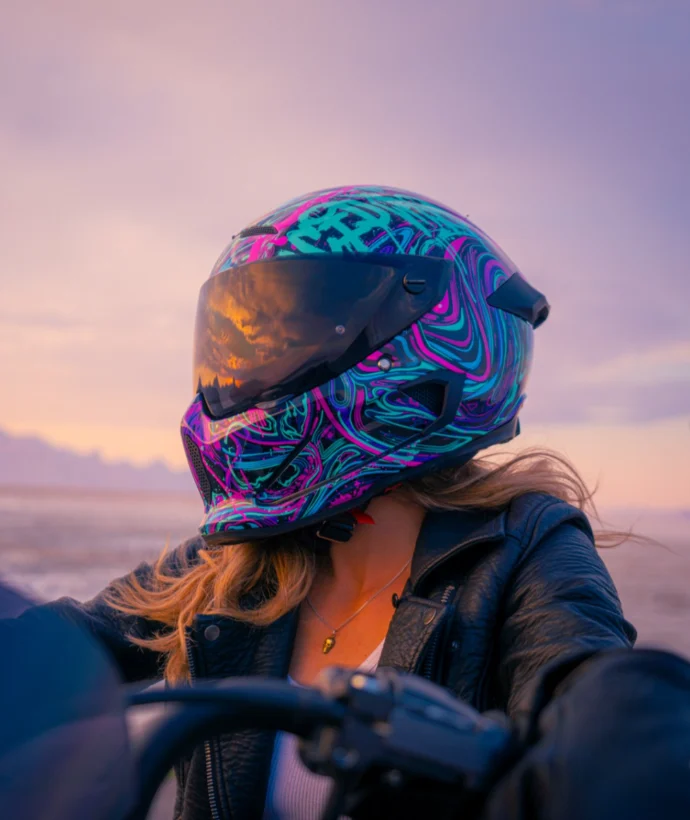 Woman in motorcycle helmet with sunset